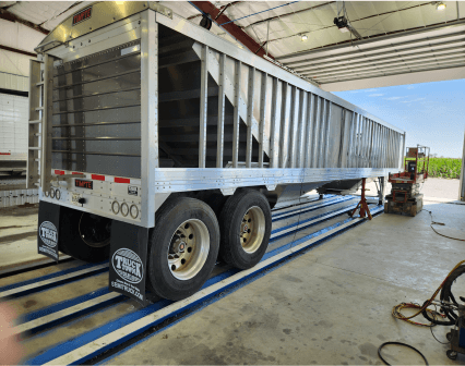 angled view of back and right side of a hopper bottom trailer in Oberholtzer's repair shop